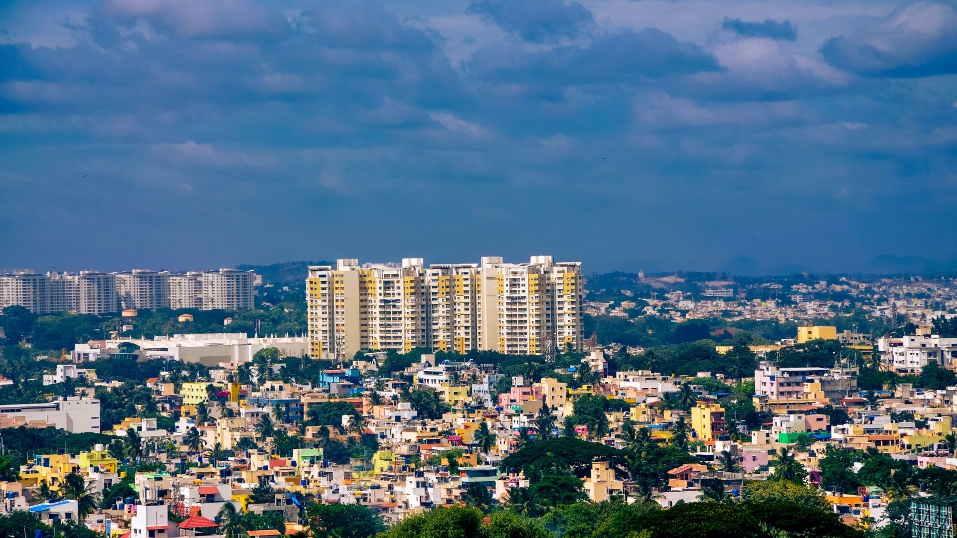 Apartment towers and tree cover across the Bengaluru skyline.