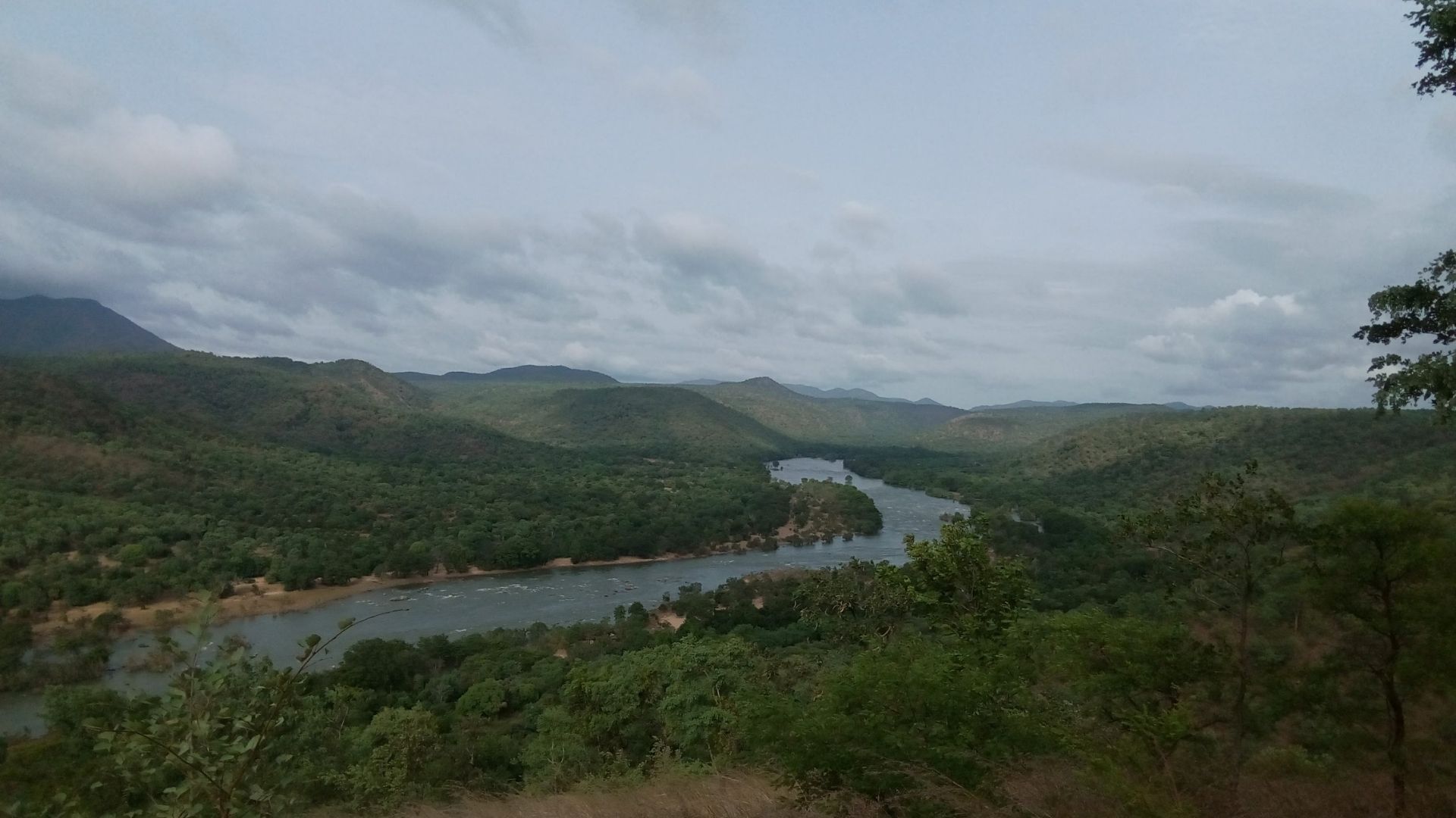 The Kaveri river winding through steep forested hills.